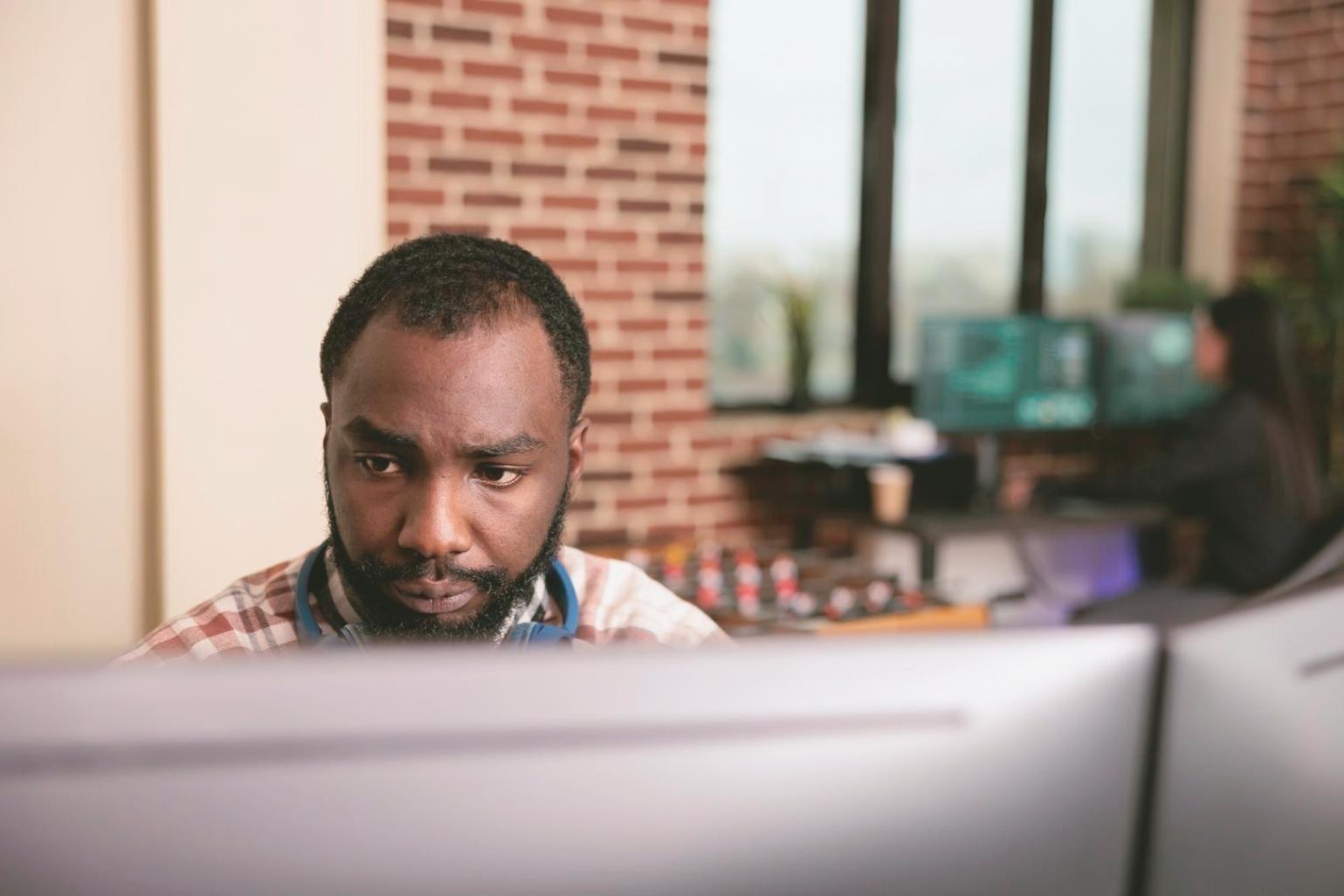 Designer analyzing mobile app wireframes and user flow diagrams on multiple screens